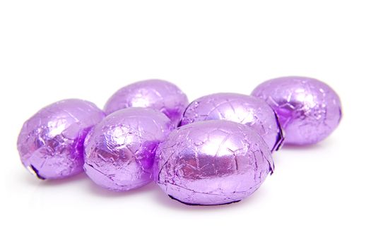 Purple chocolate easter eggs over white background