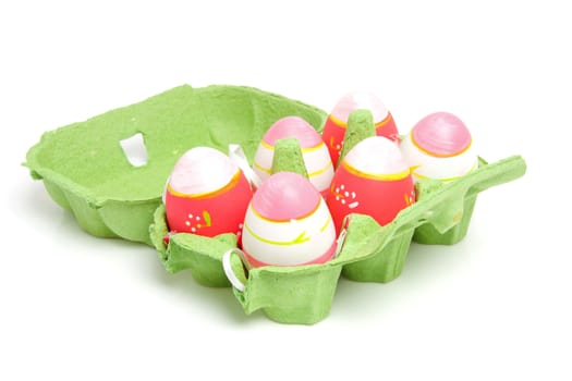 Pink easter eggs in green carton box over white background