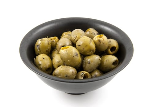 black bowl with green spicey olives over white background