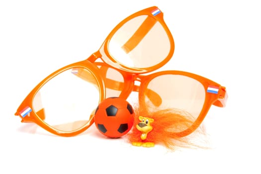 Orange soccer accessory: big glasses, ball and Dutch lion over white background