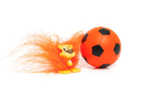 Orange soccer accessory: ball and Dutch lion over white background
