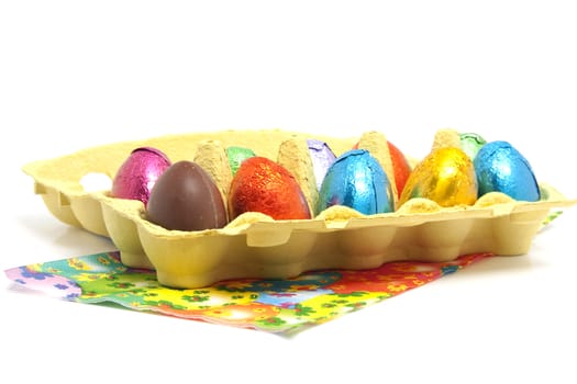 colorful chocolate easter eggs in carton box over white background