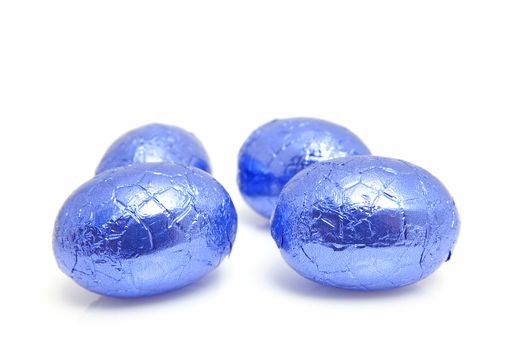 Blue chocolate easter eggs in closeup over white background