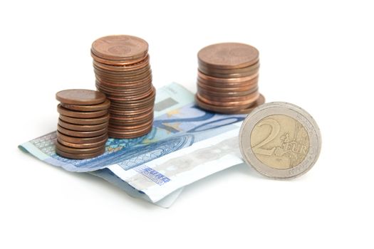 Euro money: stack of coins and paper over white background