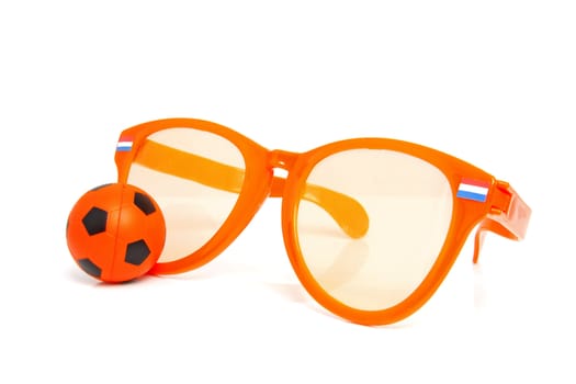 Orange soccer accessories: big glasses and ball over white background