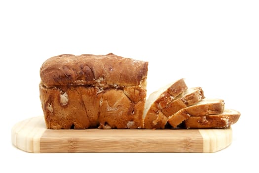 baked sugar bread in closeup on wooden cutting board over white background