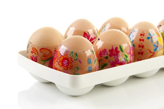 Decorated chicken eggs in holder made by children over white background