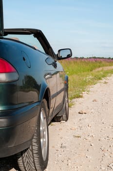 Shot of dark green cabrio on the road