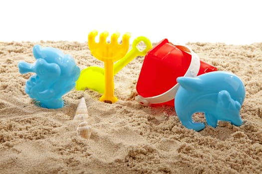 colorful plastic toys on the beach over white background