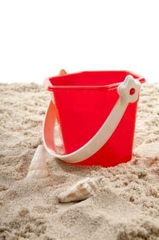 Red bucket on the beach over white backgorund