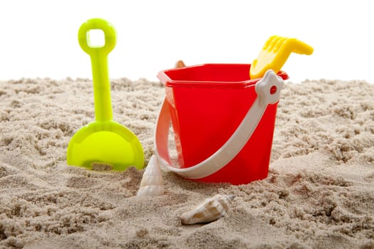 colorful plastic toys for the beach on sand over white background