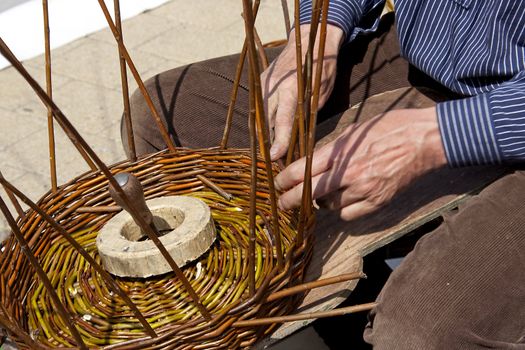 mens hand is reed weaving in closeup