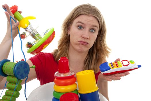 Woman with lots of colorful toys is looking tired and desperate over white background