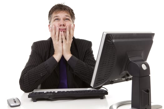 Businessman sitting behind desk is in despair, looking in the sky, over white background