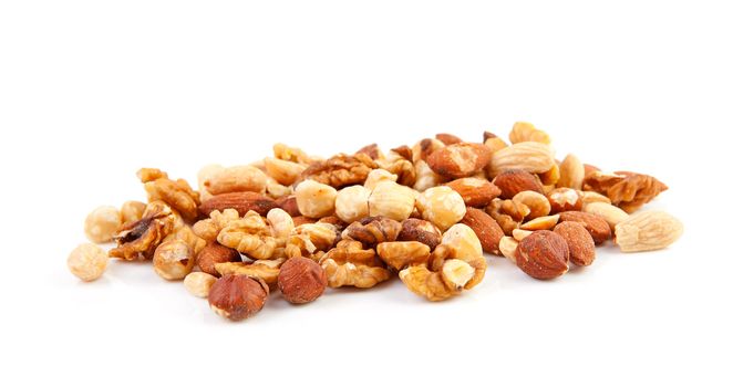 pile of raw mixed nuts isolated on white background