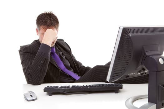 Businessman sitting behind desk is in despair over white background