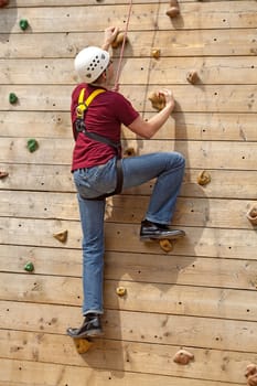 man is on climbing wall in the nature