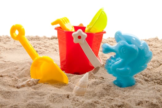 plastic toys for beach on sand over white background