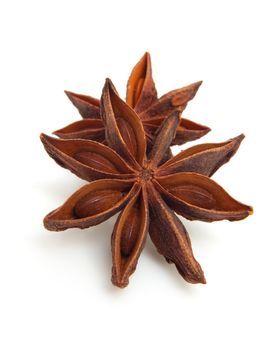 two whole star anise in closeup over white background