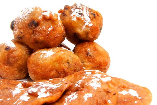 Pile of Dutch donut also known as oliebollen and apple turnovers, traditional New Year's eve food isolated on white background