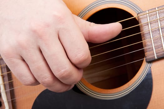 hand is playing the guitar in closeup