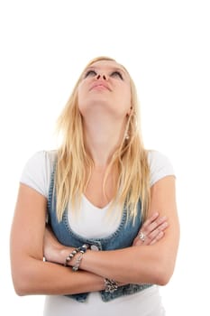 Young blonde woman is looking up with arms crossed over white background