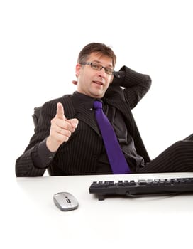 Businessman sitting behind desk is pointing at you over white background