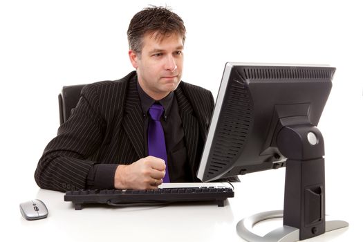 Businessman sitting behind desk is angry, strike his fist on the keyboard, over white background