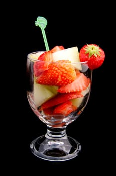 Fresh delicious fruit cocktail over black background