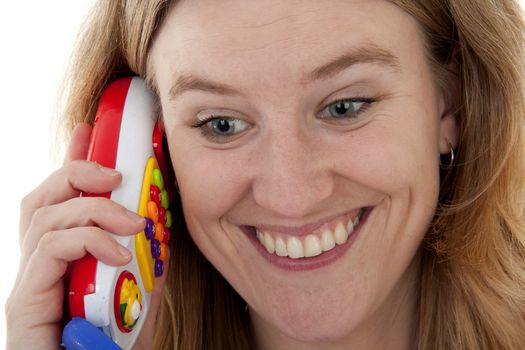woman is calling bij plastic colorful play toy in closeup