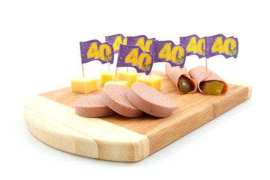 party snacks for fortieth anniversary on wooden plate over white background
