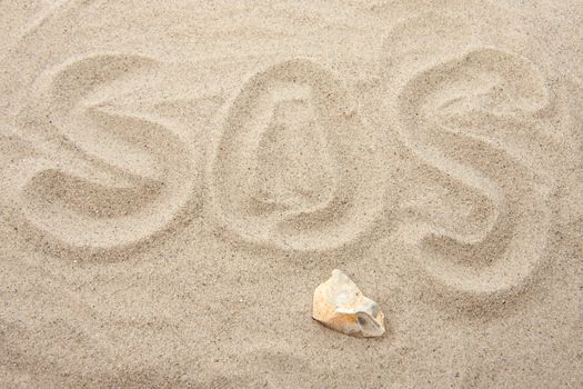 SOS letters written in sand in closeup