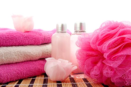 pink spa bathroom accessory on cane mat over white background