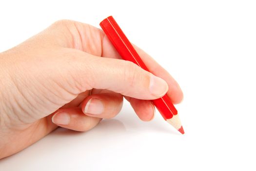 hand is holding red pencil and writes over white background