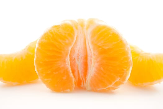 peeled mandarin in closeup over white background