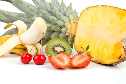 tropical fruits with strawberry, pineapple, cherries, banana and kiwi over white background