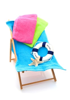 beach chair with colorful towels and life buoy over white background
