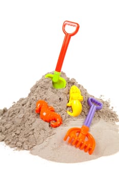 plastic toys for beach and vacation on sand over white background