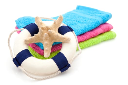 summer gear; colorful towel, life buoy and starfish over white background