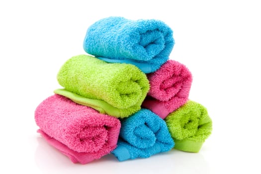 stack of colorful towels rolled isolated on white background