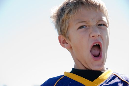 Young boy yelling during the game.