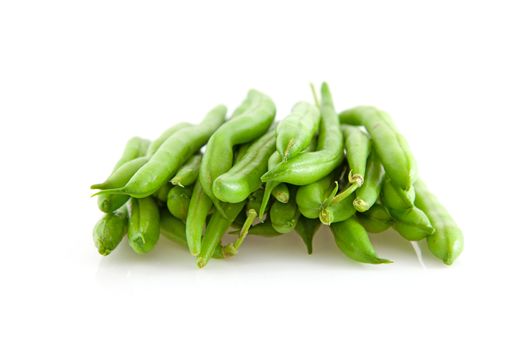 pile of raw long green beans over white background