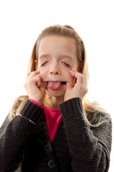Girl is making funny face, she sticks her tongue out and pulling eyes over white background