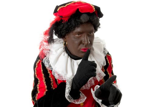 Zwarte piet ( black pete) typical Dutch character part of a traditional event celebrating the birthday of Sinterklaas in december over white background making hush sign