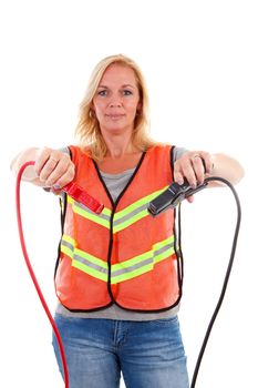 Woman in safety vest holding car jumper cables over white background