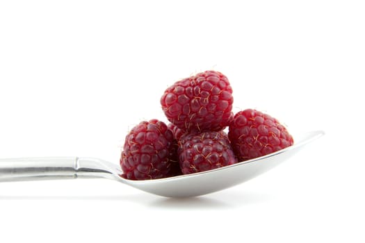 Fresh raspberrie on spoon in closeup isolated on white background