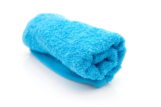 rolled blue towel in closeup over white background