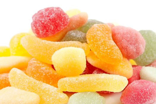 pile of colorful sugar candy in closeup over white background