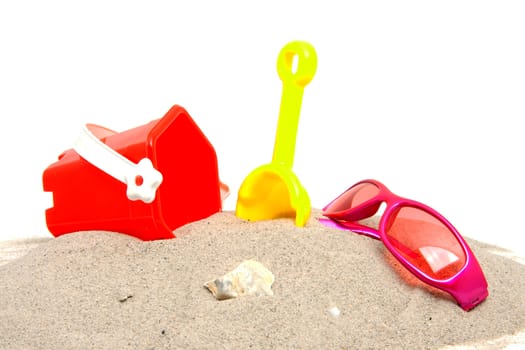 pink sunglasses and beach toys over white background