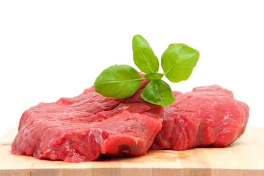 raw steak meat on cutting board in closeup over white background